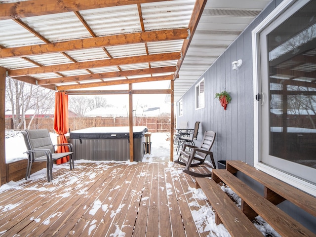 snow covered deck with a hot tub