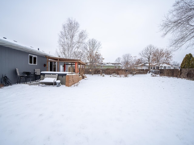 snowy yard featuring a hot tub