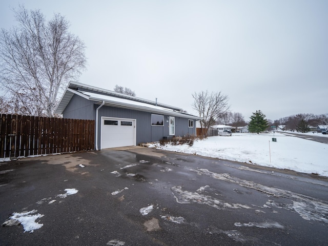 view of snowy exterior featuring a garage