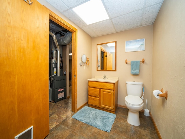 bathroom featuring toilet, a paneled ceiling, and vanity