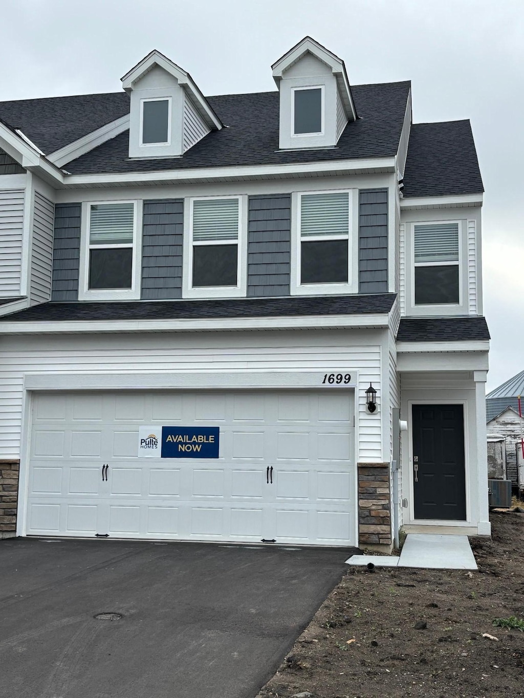 view of front facade featuring central AC unit and a garage