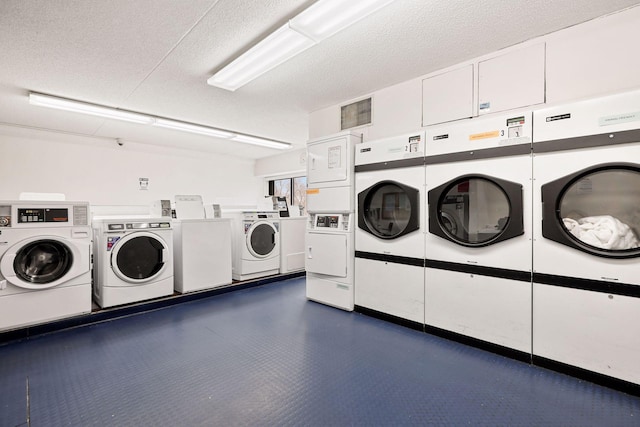 clothes washing area featuring stacked washer / drying machine, washing machine and clothes dryer, and a textured ceiling