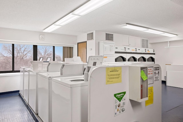 laundry room featuring a textured ceiling and washing machine and clothes dryer