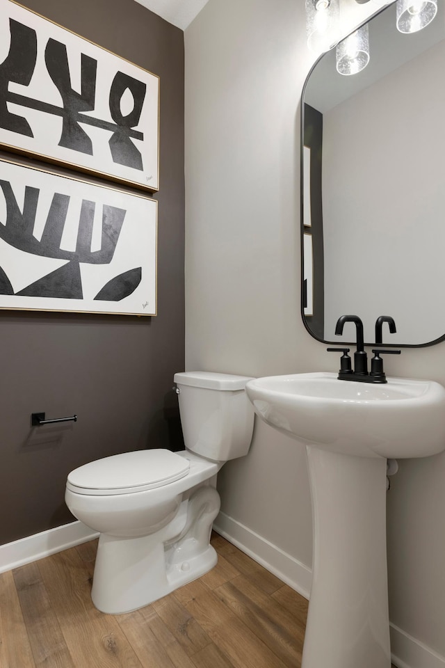 bathroom featuring toilet, wood-type flooring, and sink