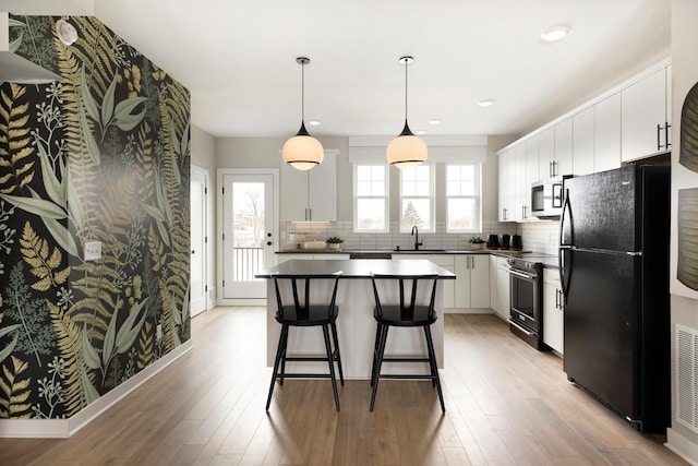 kitchen featuring white cabinets, stainless steel appliances, a healthy amount of sunlight, and sink