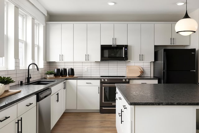 kitchen with black appliances, white cabinetry, sink, and a wealth of natural light