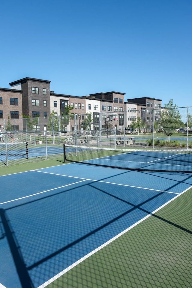 view of tennis court featuring basketball hoop