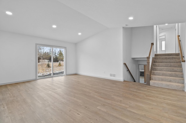 unfurnished living room featuring light hardwood / wood-style flooring and lofted ceiling