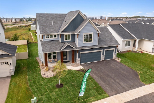 view of front of house featuring covered porch, a garage, and a front lawn