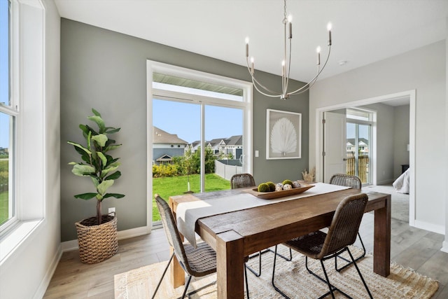 dining area featuring light hardwood / wood-style flooring and an inviting chandelier