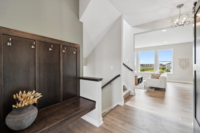 stairway with a notable chandelier and hardwood / wood-style flooring