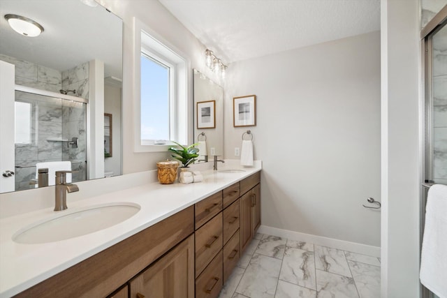 bathroom with a textured ceiling, vanity, and walk in shower