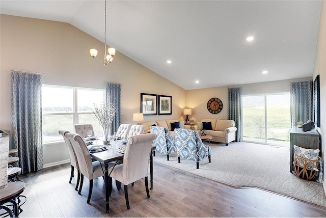 dining space featuring a wealth of natural light, light hardwood / wood-style floors, vaulted ceiling, and a notable chandelier