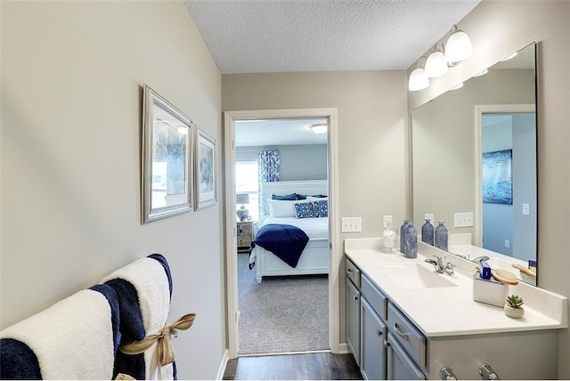 bathroom with vanity, wood-type flooring, and a textured ceiling