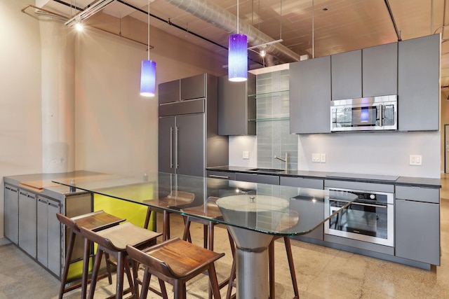 kitchen with gray cabinets, dark countertops, and appliances with stainless steel finishes