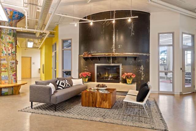 living area featuring concrete floors and a large fireplace