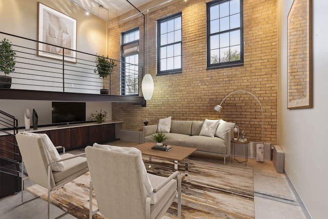 living area with baseboards, brick wall, a high ceiling, marble finish floor, and track lighting