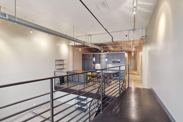 corridor featuring baseboards, an upstairs landing, and visible vents
