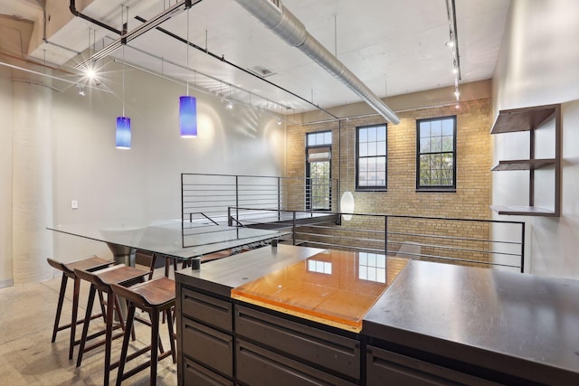 kitchen with rail lighting and brick wall