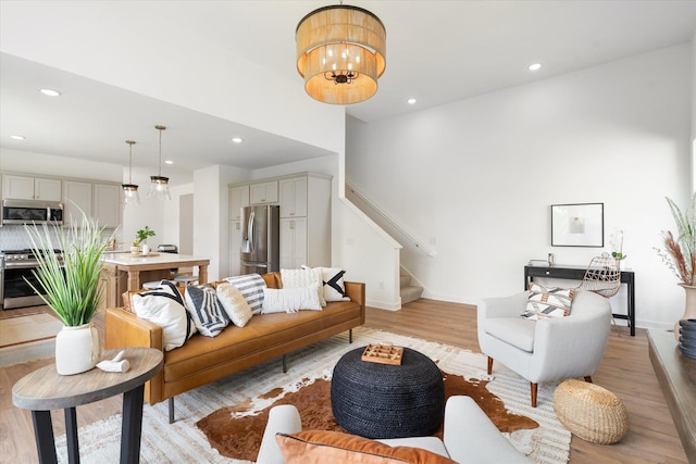 living room with an inviting chandelier and light wood-type flooring