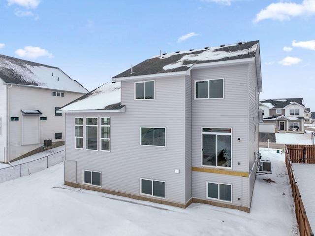 snow covered back of property featuring central air condition unit