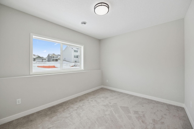 unfurnished room with light carpet and a textured ceiling