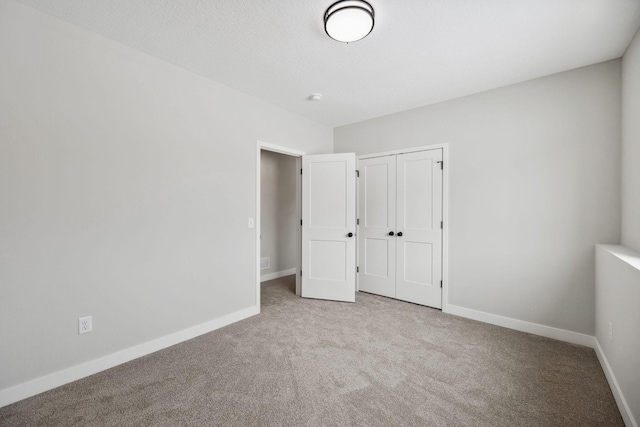 unfurnished bedroom with light carpet and a closet