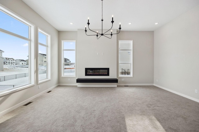 unfurnished living room with a notable chandelier and light colored carpet