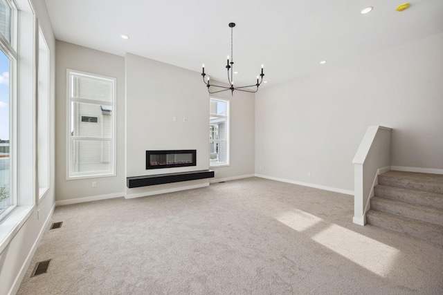 unfurnished living room featuring light carpet and an inviting chandelier