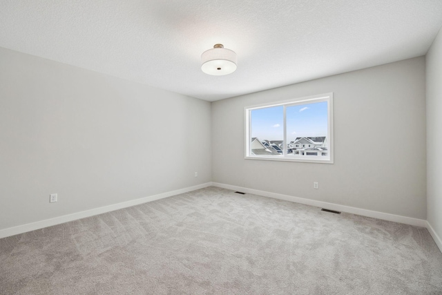 carpeted spare room with a textured ceiling