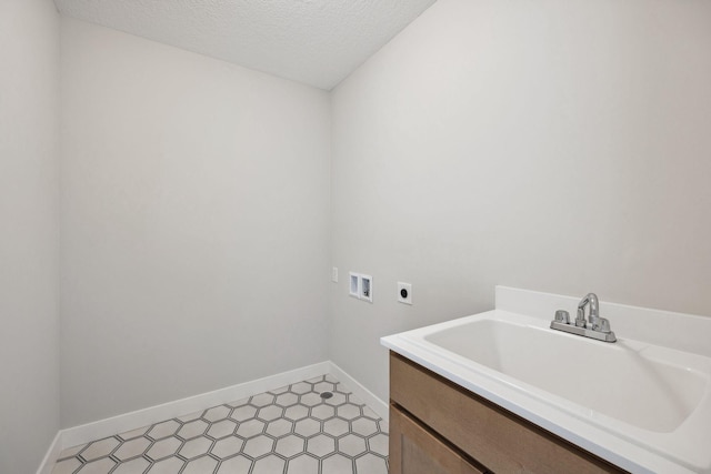 clothes washing area featuring sink, hookup for a washing machine, a textured ceiling, and electric dryer hookup