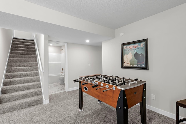 playroom with baseboards, a textured ceiling, and carpet flooring