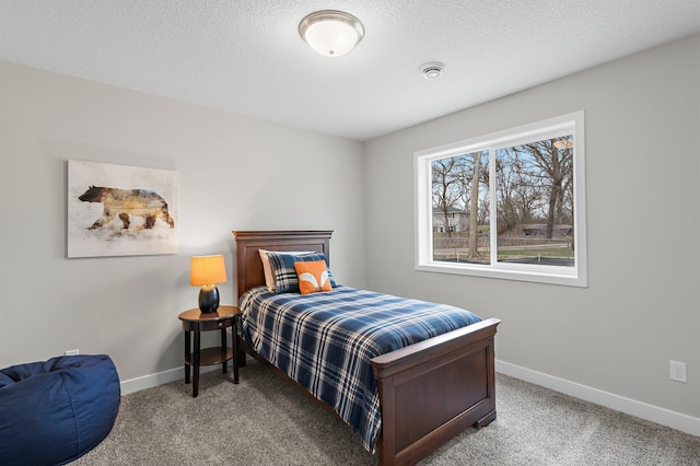bedroom featuring a textured ceiling, carpet flooring, and baseboards