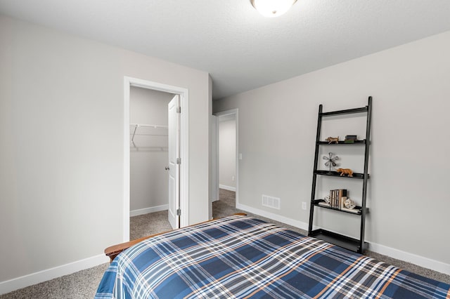 bedroom with baseboards, visible vents, and carpet