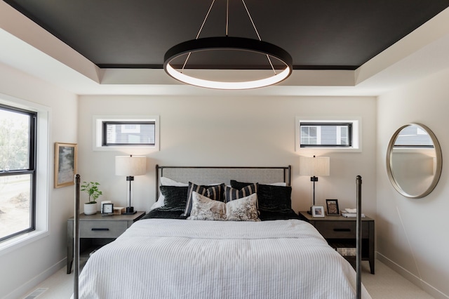 carpeted bedroom featuring a raised ceiling