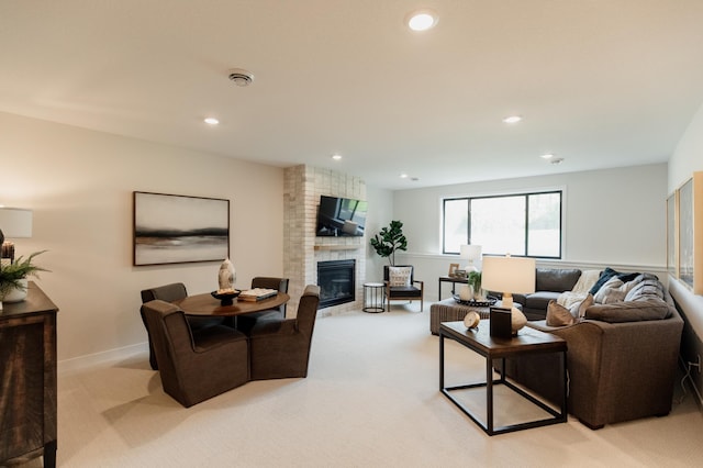 living room featuring light colored carpet and a brick fireplace