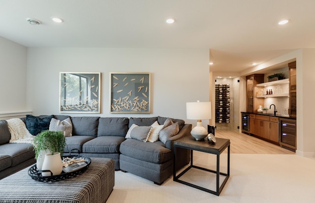 living room with light wood-type flooring, wine cooler, and indoor wet bar