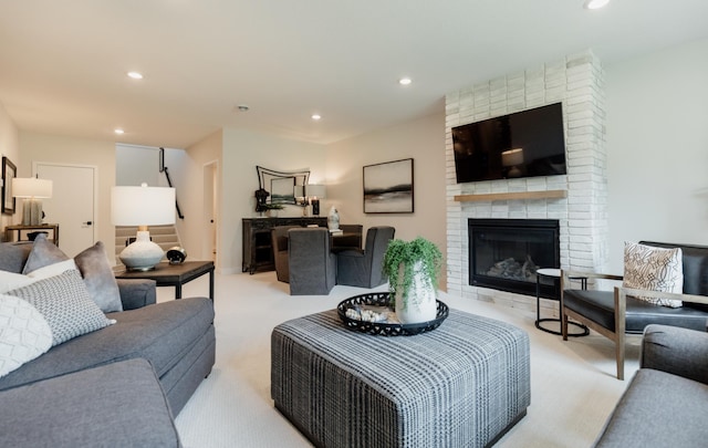 living room featuring light colored carpet and a brick fireplace