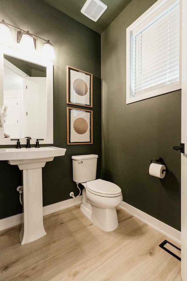 bathroom with wood-type flooring and toilet