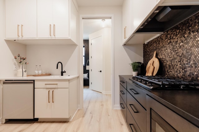 kitchen with dishwasher, white cabinets, ventilation hood, light wood-type flooring, and gas cooktop