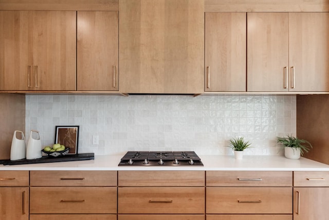 kitchen with backsplash, light brown cabinets, and stainless steel gas stovetop