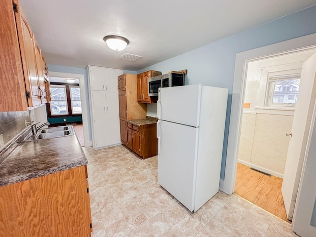 kitchen with white refrigerator, light hardwood / wood-style floors, and sink