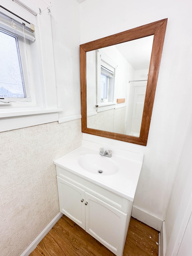 bathroom with vanity, wood-type flooring, and tile walls