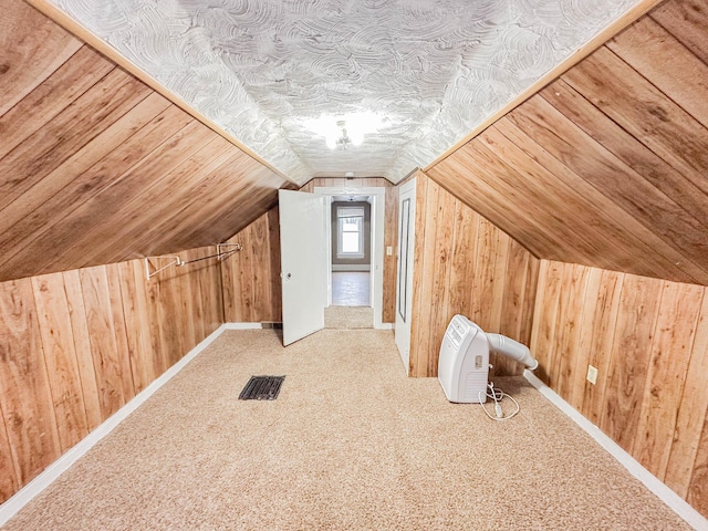 bonus room featuring carpet flooring, vaulted ceiling, and wood walls