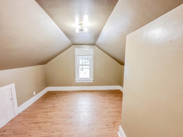 bonus room featuring a textured ceiling, light hardwood / wood-style floors, and lofted ceiling