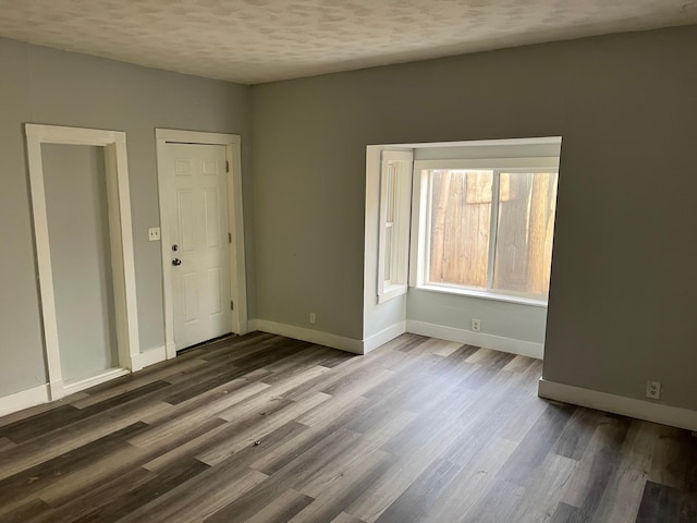 spare room featuring a textured ceiling and hardwood / wood-style flooring