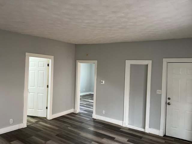 spare room with dark hardwood / wood-style flooring and a textured ceiling