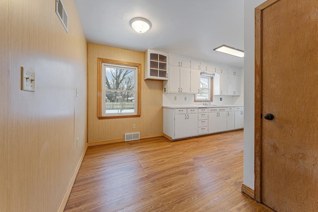 kitchen with light hardwood / wood-style floors, white cabinetry, and sink