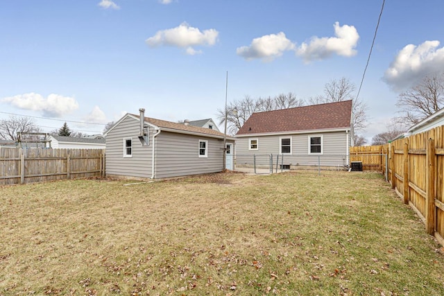 rear view of house featuring a lawn and central AC