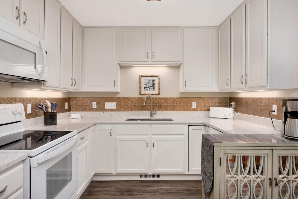 kitchen featuring white cabinetry, white appliances, sink, and light stone counters